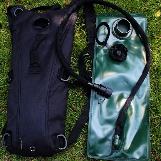 sac-a-dos-hydratation-noir-sur-herbe-avec_poche