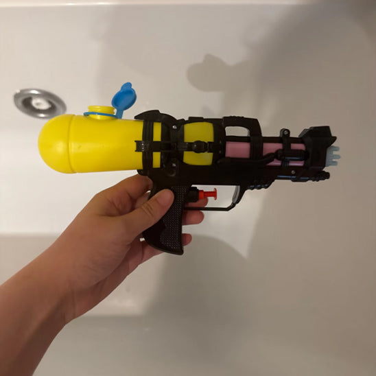 Pistolet a eau jaune fond salle de bain
